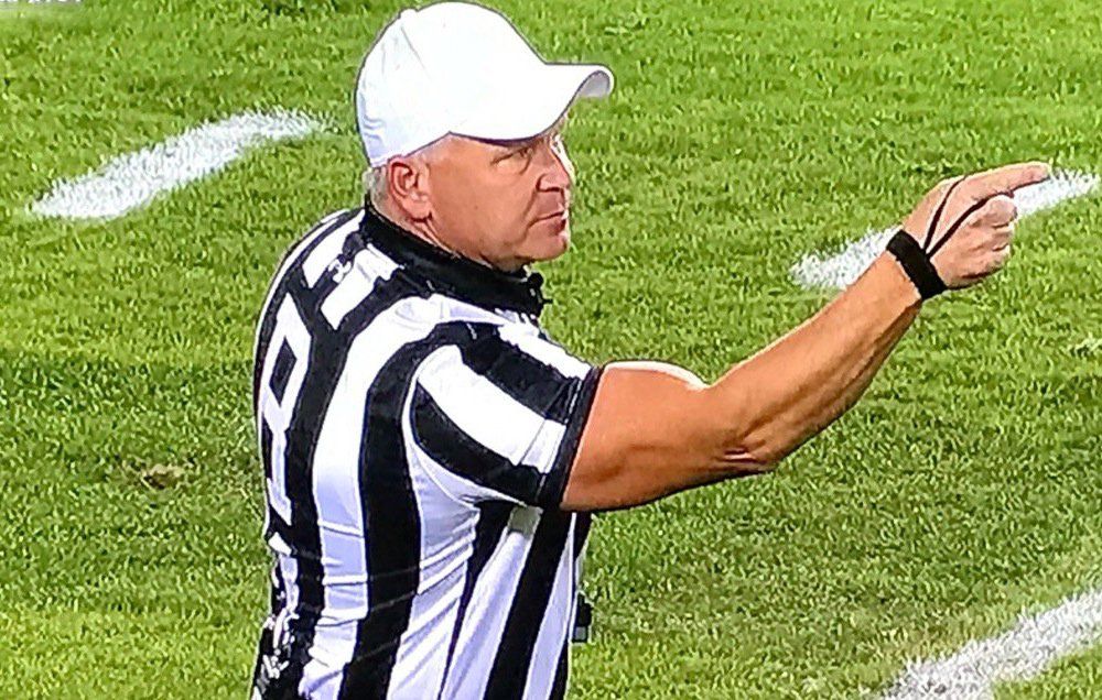 Division 1 football referee in a white hat on the field