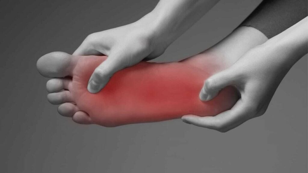 Senior holding the heel and arch where plantar fasciitis hurts